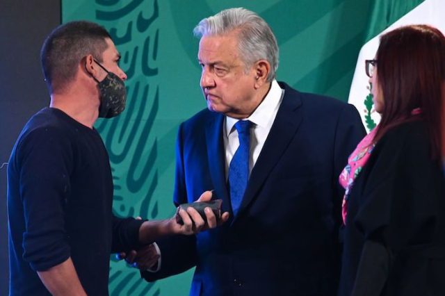 La persona que se coló a la conferencia mañanera del presidente de México, Andrés Manuel López Obrador, intentó darle algo cuando se acercó a él.